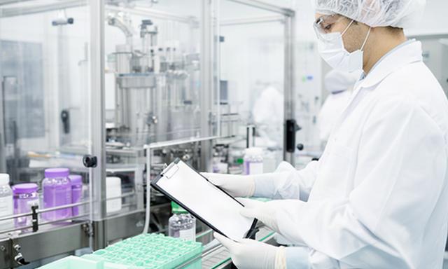 Pharmaceutical packaging supervisor reviewing batch traceability records in a clean facility